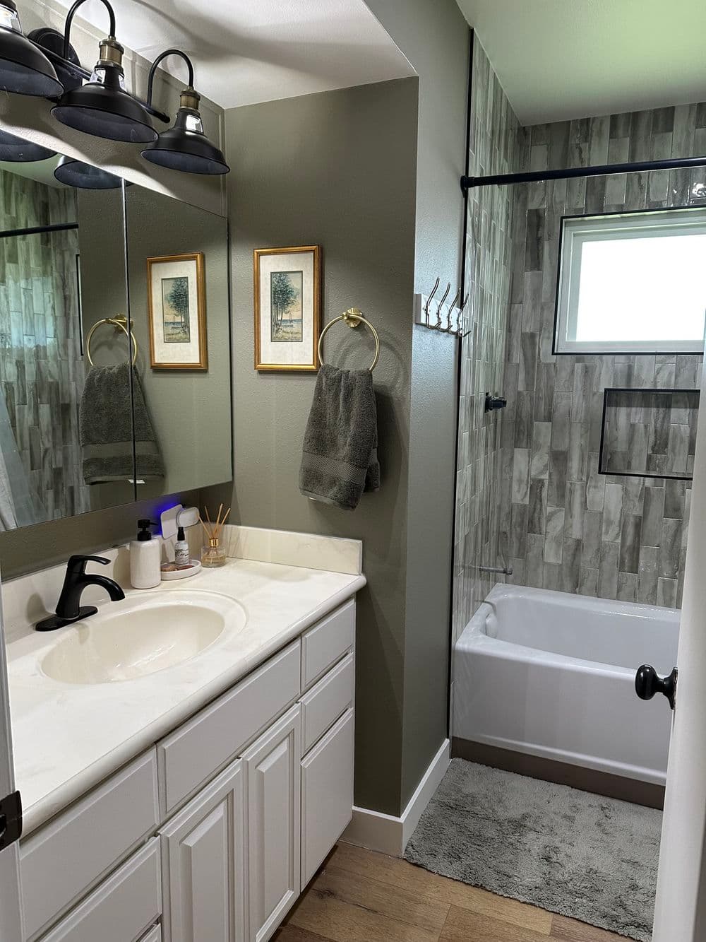 Modern bathroom with shower, white vanity, gray walls, and stylish decor.