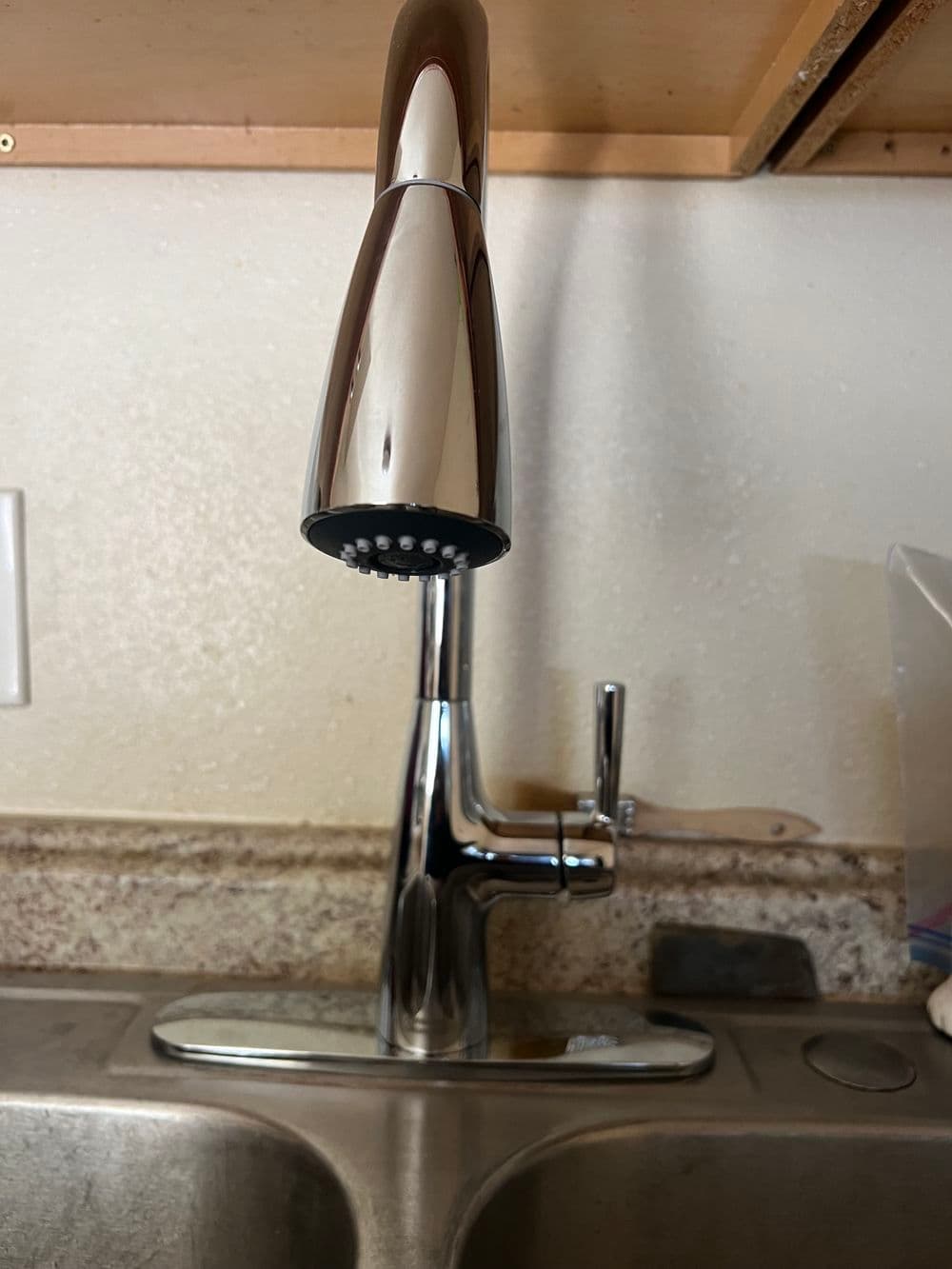 Modern chrome kitchen faucet with pull-down spray head and single lever control.